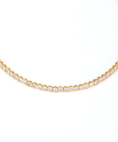 Gold necklace with clear stones on a white background