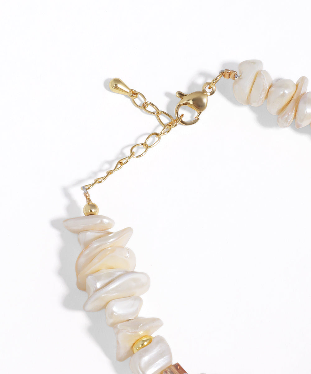 Bracelet with shell beads and gold chain on a white background