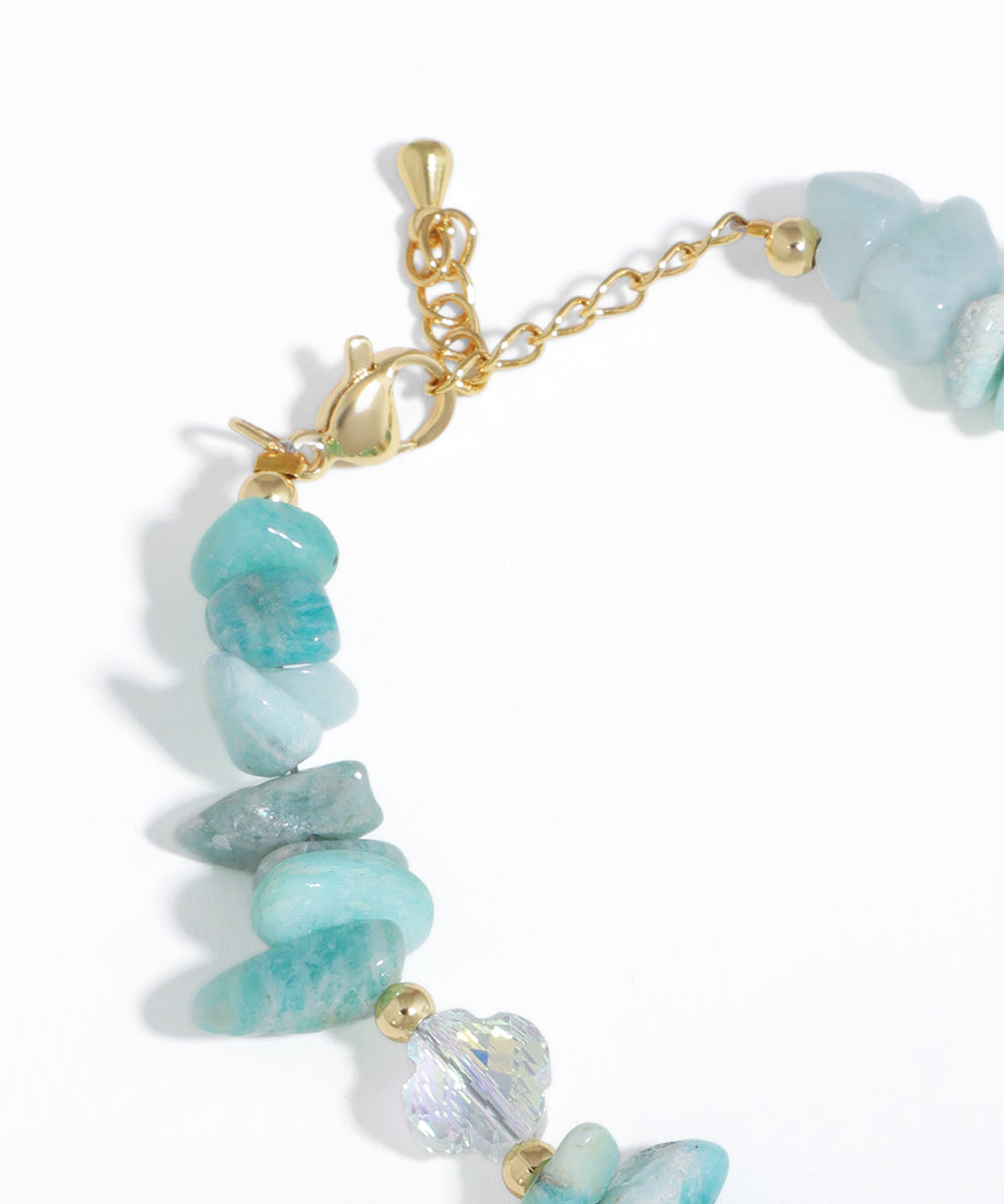Bracelet with turquoise stones and gold accents on a white background