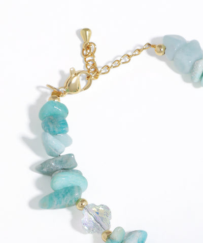 Bracelet with turquoise stones and gold accents on a white background