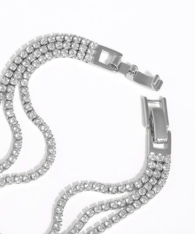 Silver chain bracelet with clear gemstones on a white background