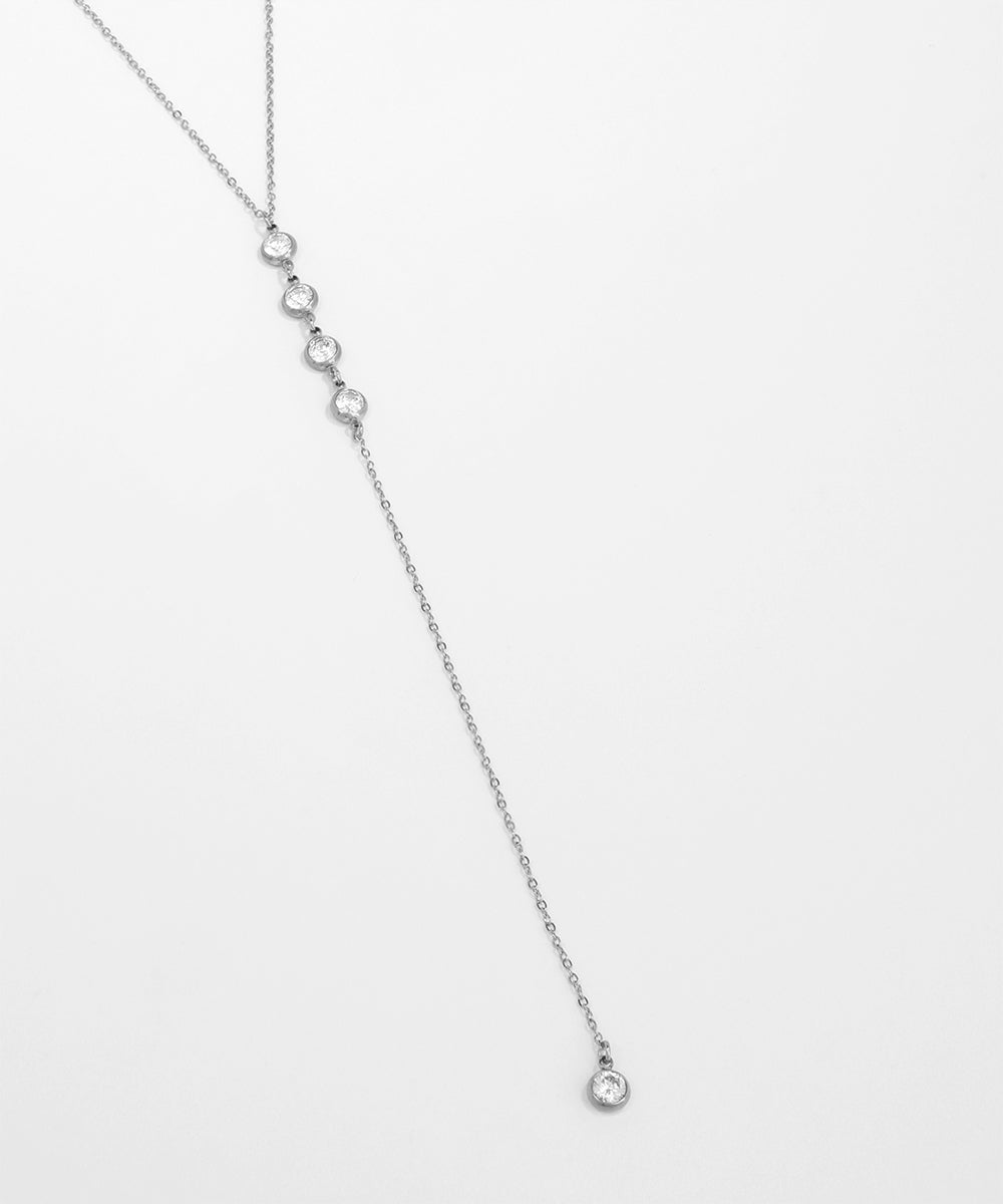 Silver necklace with small beads on a light gray background