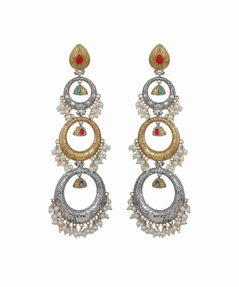 Pair of ornate earrings with circular designs and gemstone accents on a white background