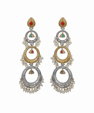 Pair of ornate earrings with circular designs and gemstone accents on a white background