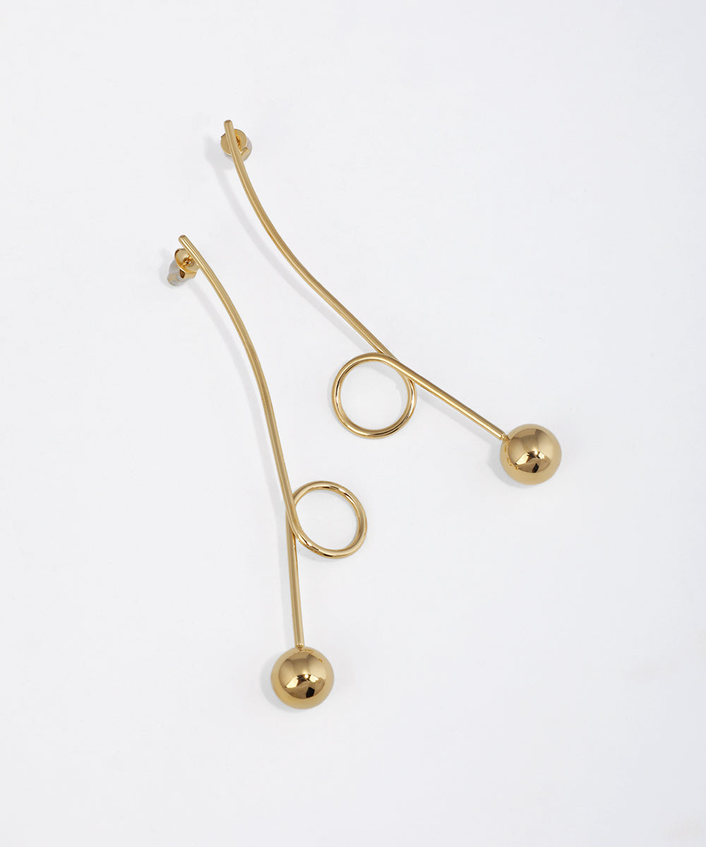 Gold-tone drop earring with a curved linear bar, small loop, and polished sphere at the end