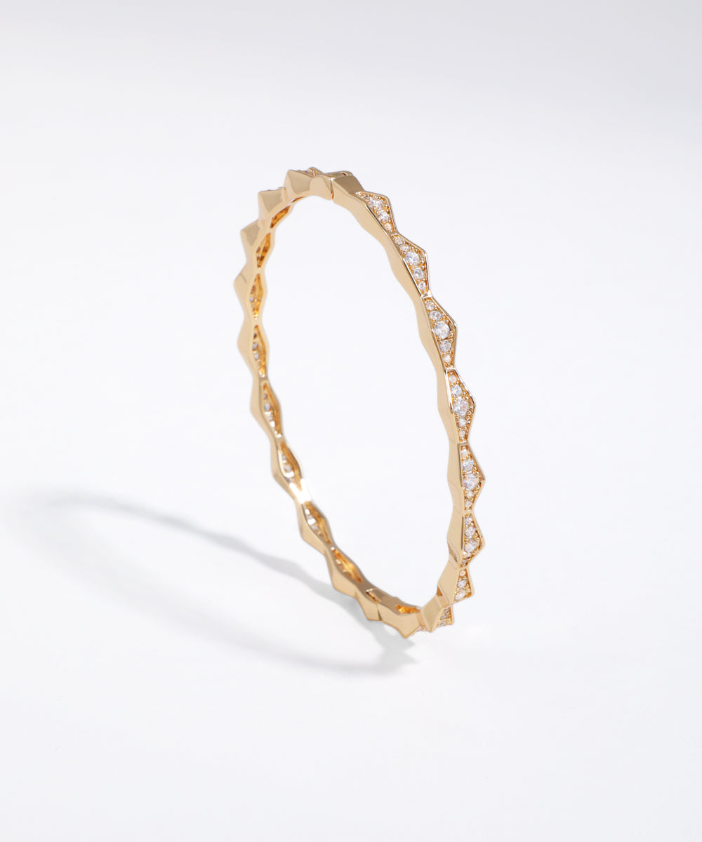 Gold bracelet with diamond accents on a white background