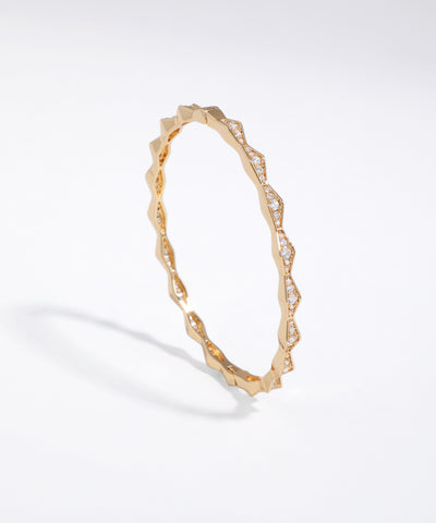 Gold bracelet with diamond accents on a white background