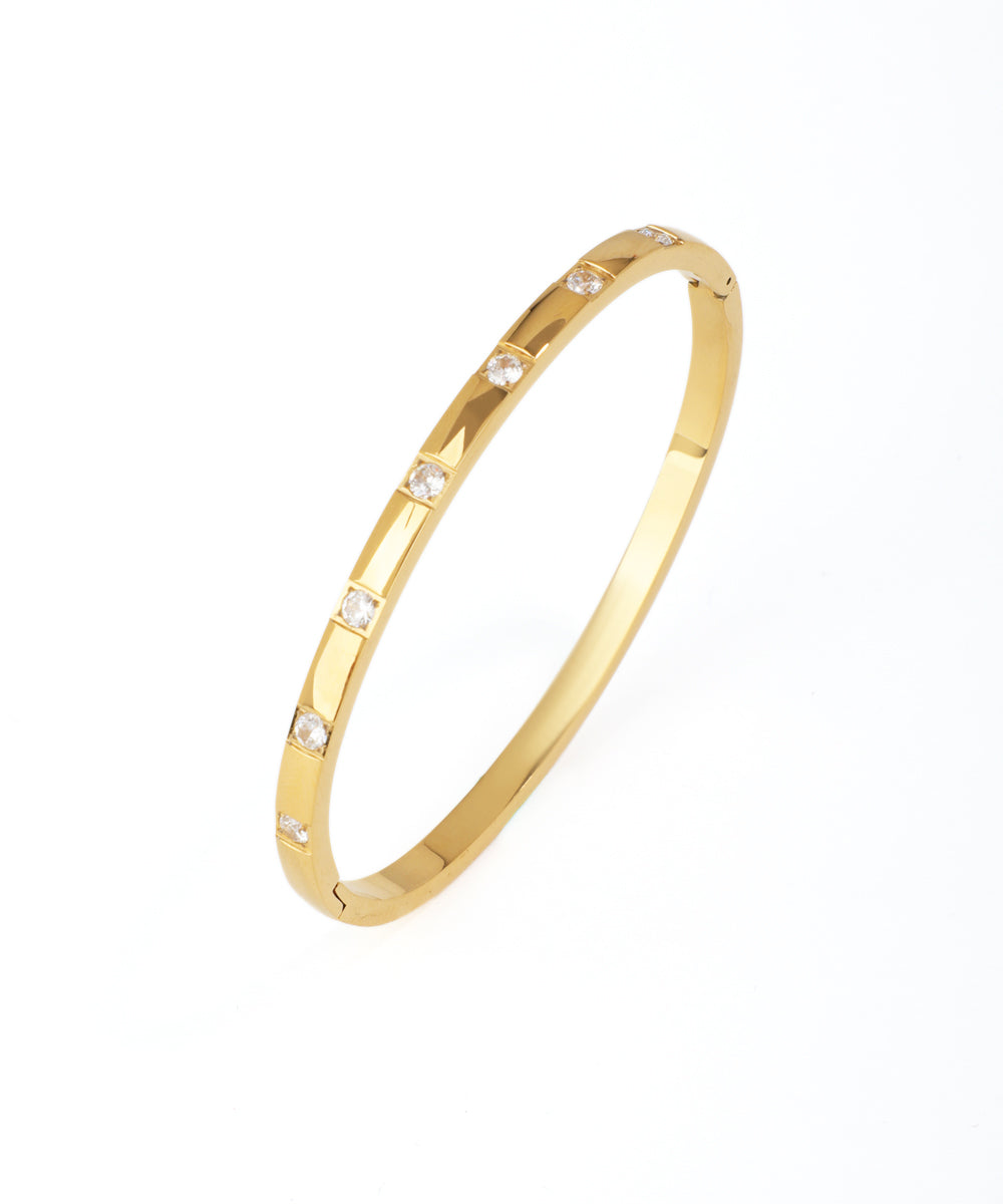 Gold bracelet with small diamonds on a white background