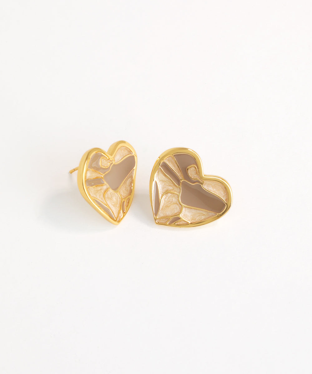 Heart-shaped earrings with gold frame and brown center on a white background