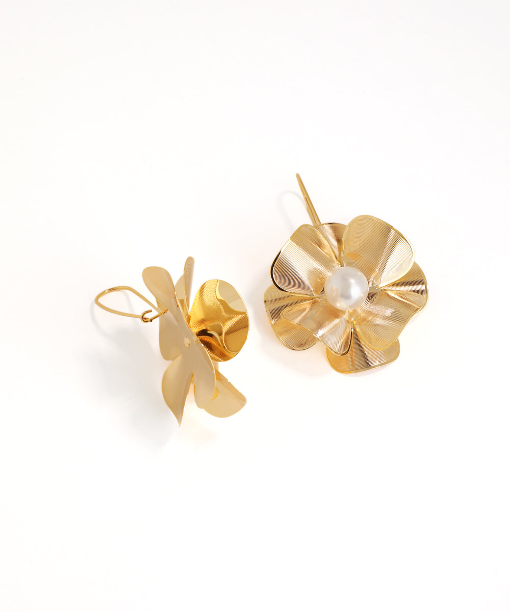 Gold earrings with a pearl center on a white background