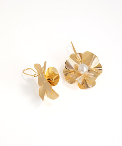 Gold earrings with a pearl center on a white background