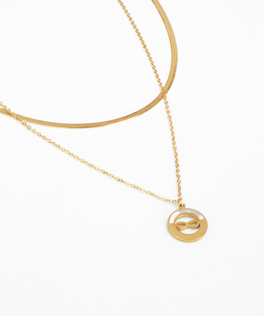 Gold necklace with a circular pendant on a white background