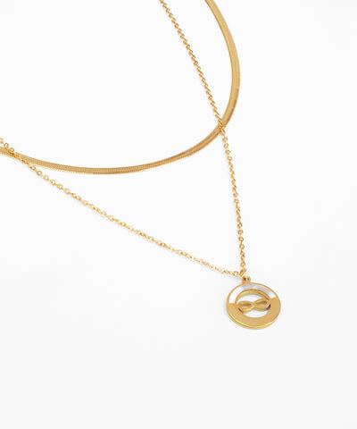 Gold necklace with a circular pendant on a white background