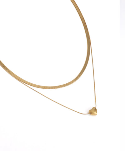 Gold necklace with a heart pendant on a white background