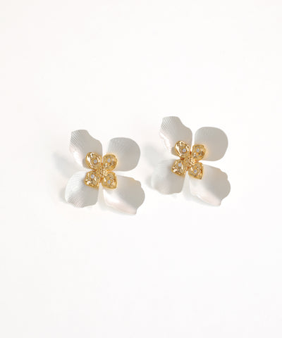 Pair of white flower-shaped earrings with gold centers on a white background