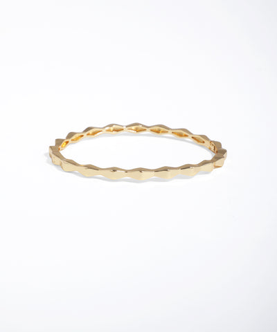 Gold ring with a textured design on a white background