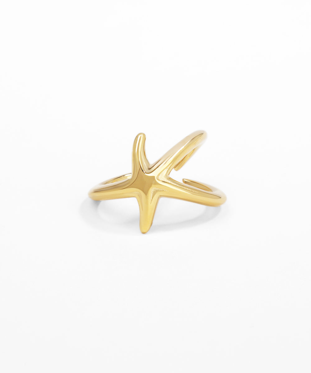 Gold starfish-shaped ring on a white background