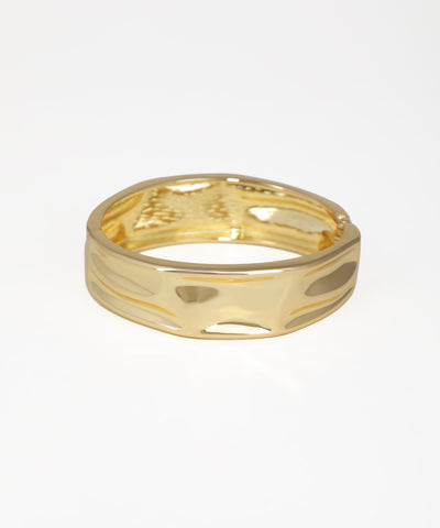 Gold ring with a textured design on a white background