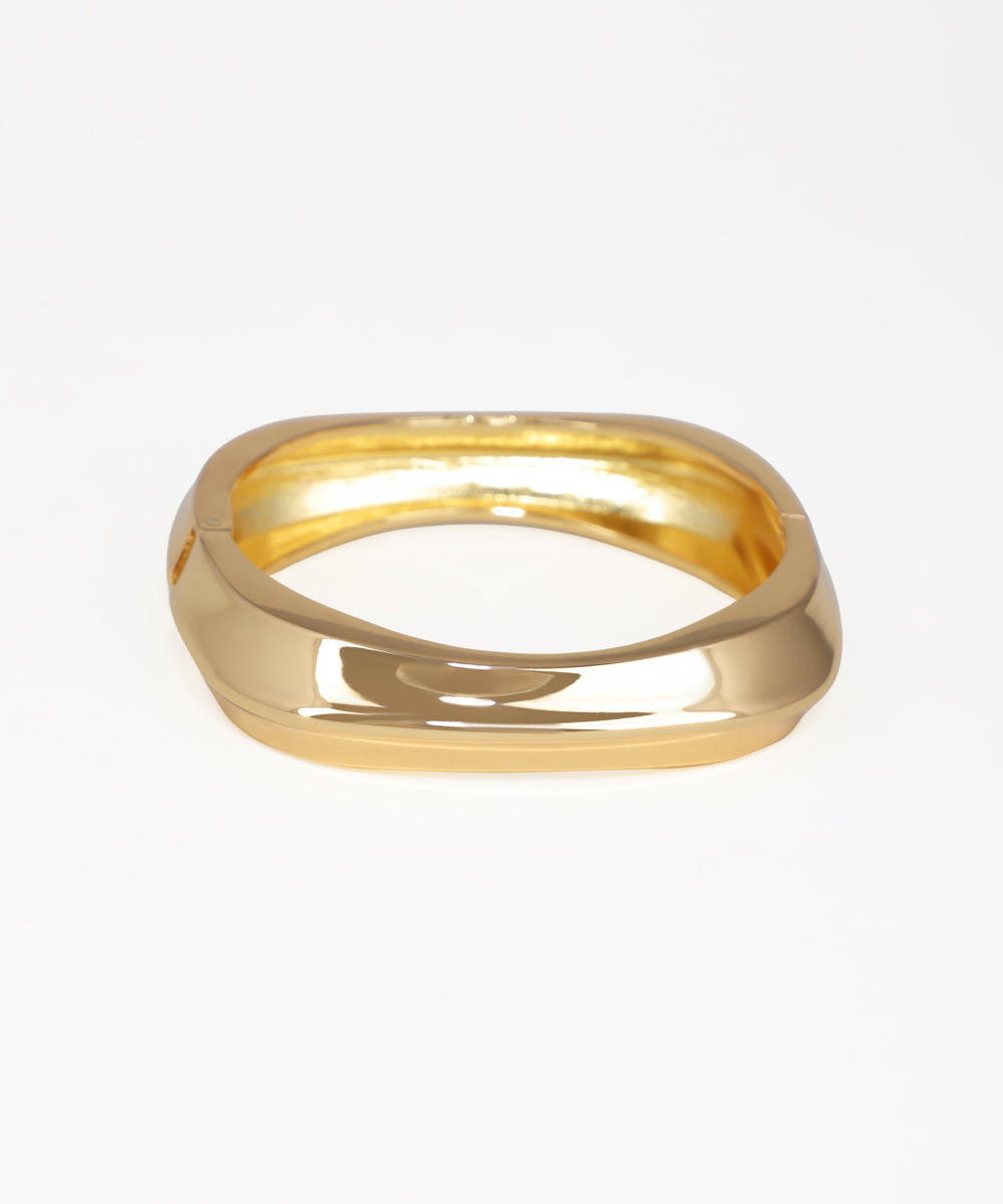 Gold-tone bangle kada with a wide, sculptural design and smooth finish