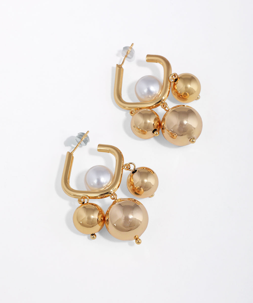 Gold-tone earrings with square hoops featuring faux pearls and polished sphere drops