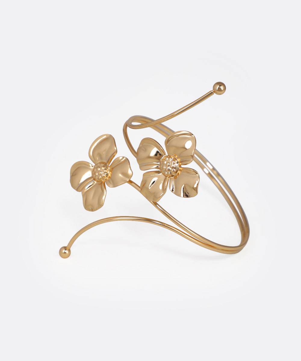 Gold floral bracelet on a light gray background