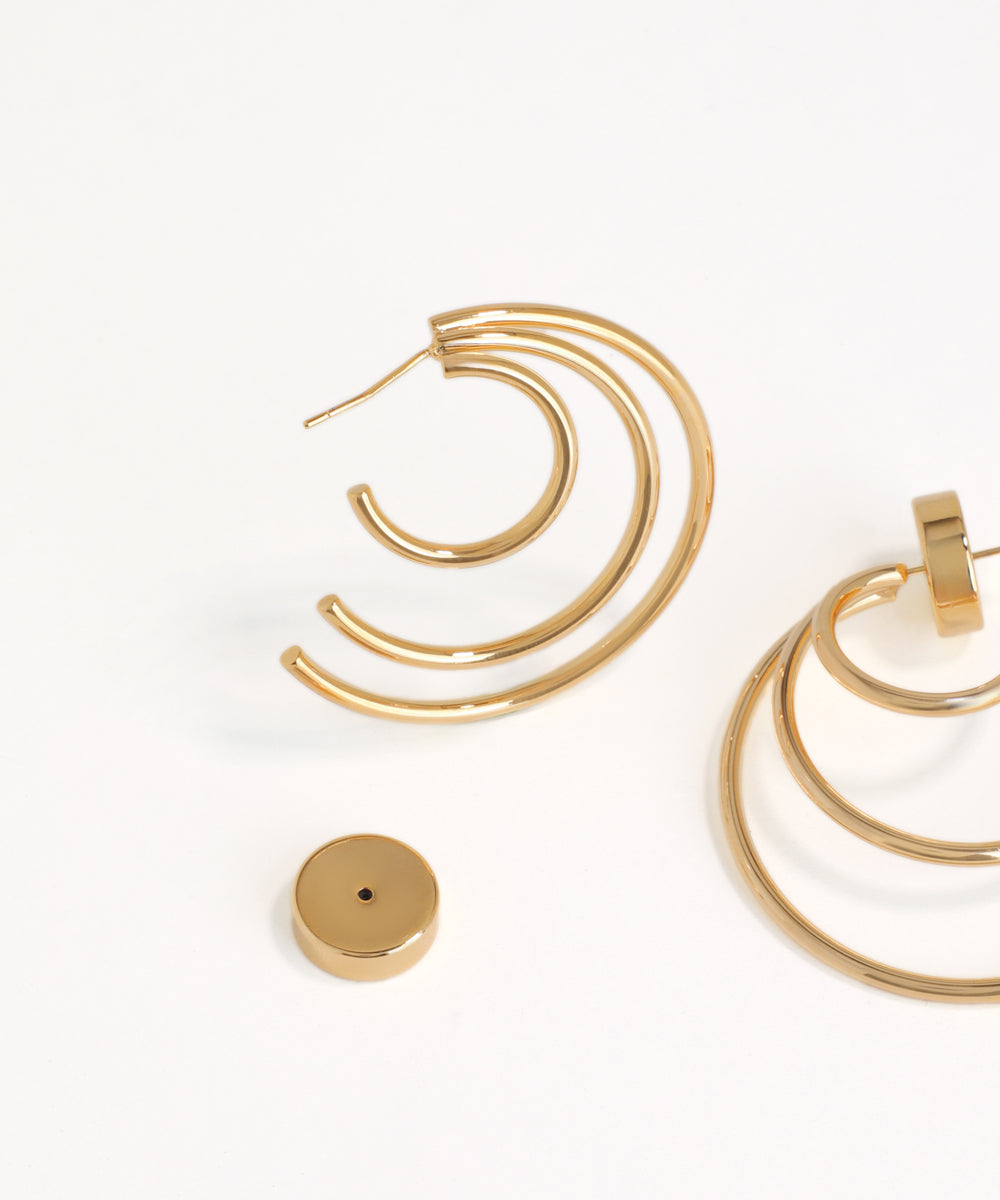 Gold hoop tiered earrings on a white background