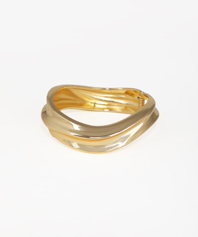Gold ring with wavy design on a white background