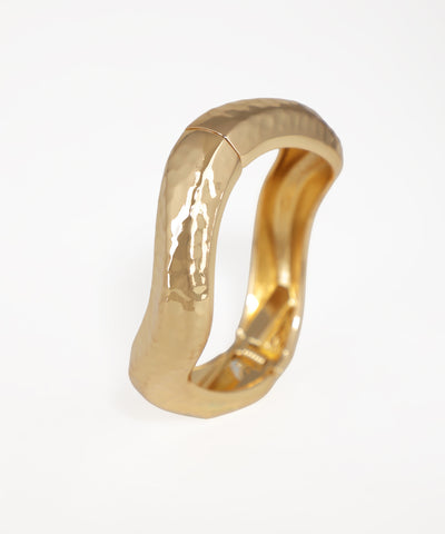 Gold ring with a textured surface on a white background