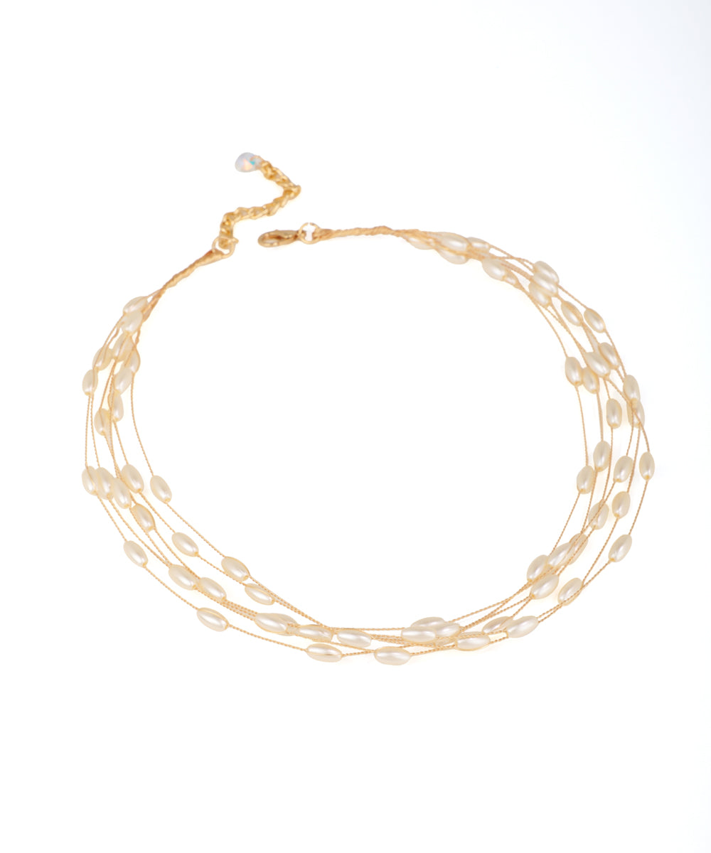 Gold-tone necklace with multiple strands of elongated faux pearls, lobster clasp and extender.