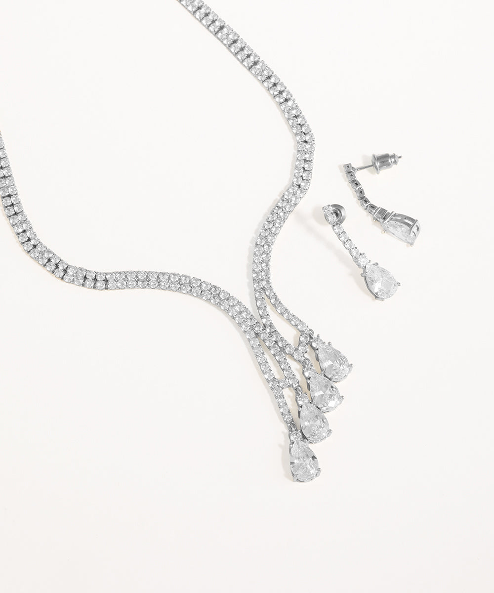 Silver necklace and earrings set on a white background
