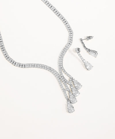 Silver necklace and earrings set on a white background
