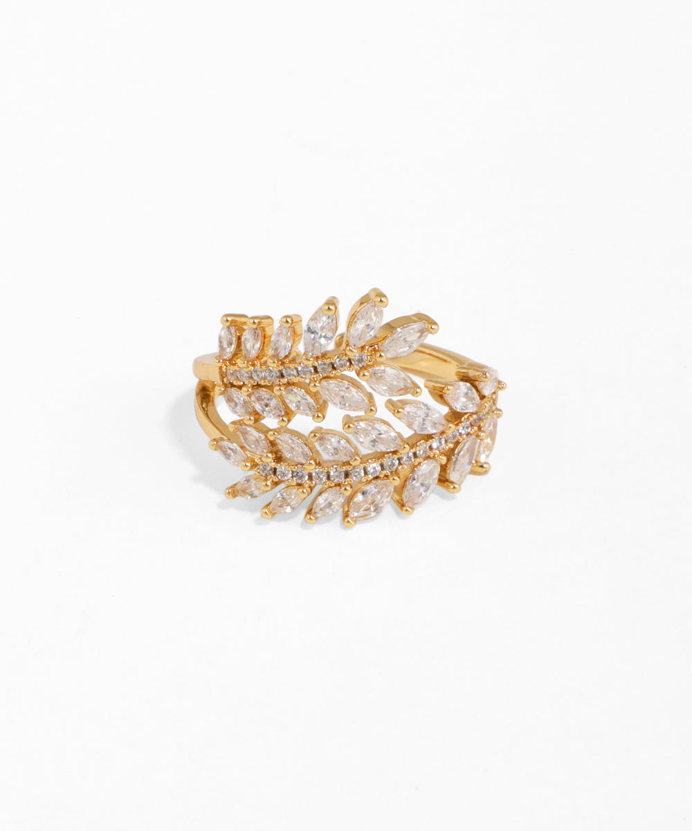 Gold and crystal leaf-shaped ring on a white background