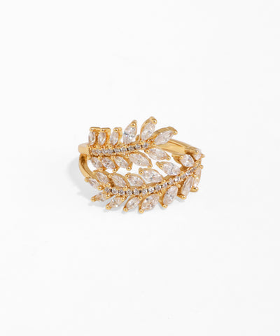 Gold and crystal leaf-shaped ring on a white background