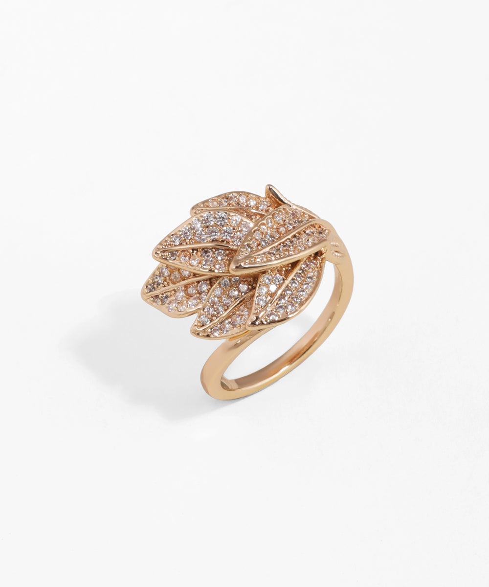 Rose gold ring with leaf design and embedded diamonds on a white background