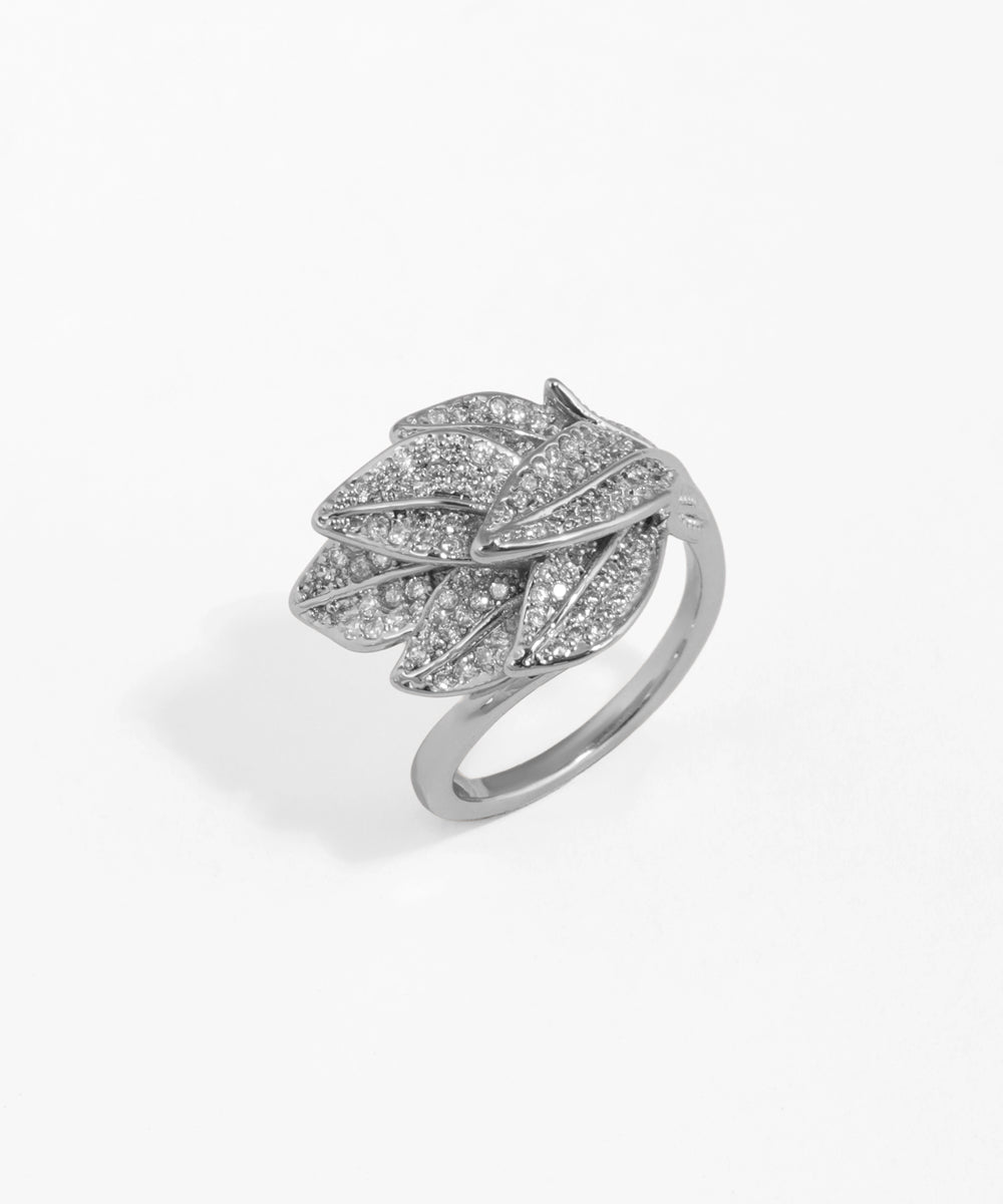 Silver leaf-shaped ring with gemstones on a white background