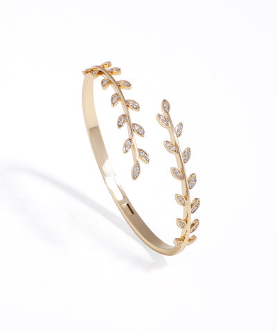 Gold-tone bracelet with sparkling leaf vine design and hinge closure.