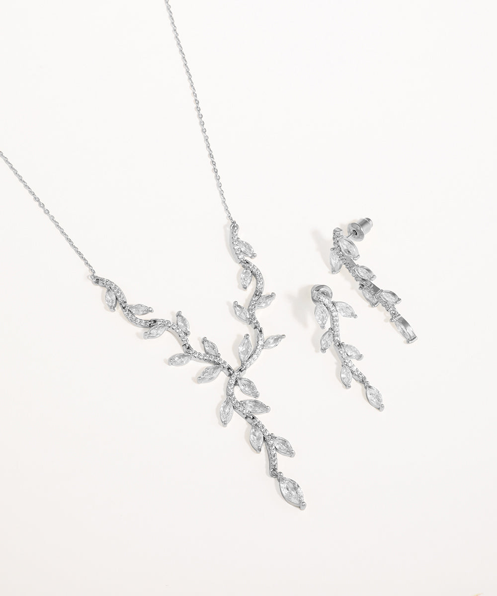 Silver necklace and earrings set on a white background