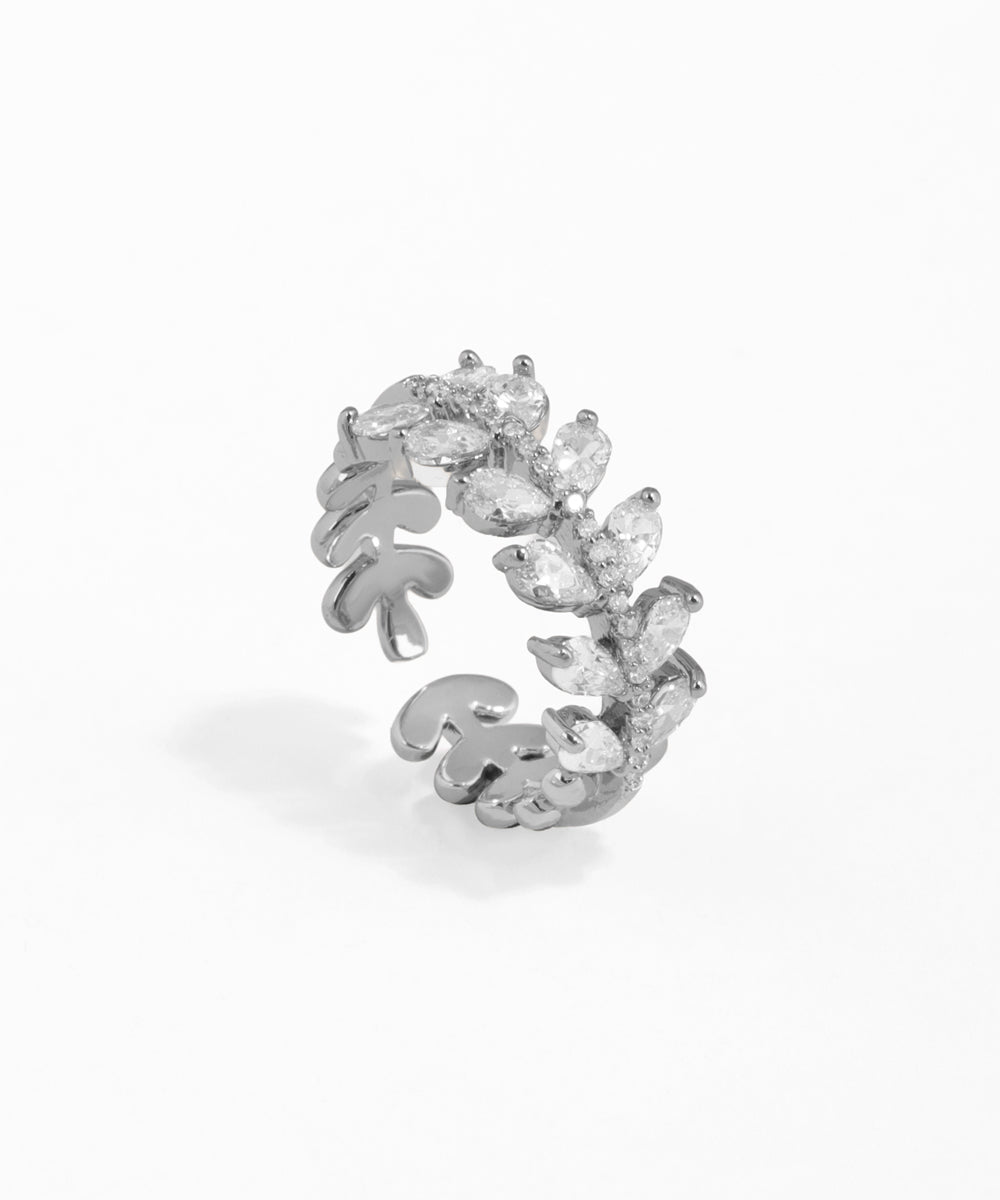 Silver ring with leaf design and clear stones on a white background