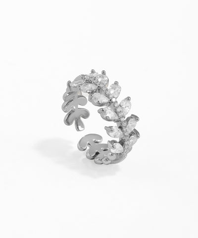 Silver ring with leaf design and clear stones on a white background