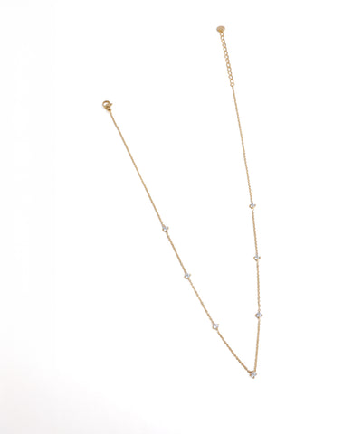 Gold necklace with small beads on a white background