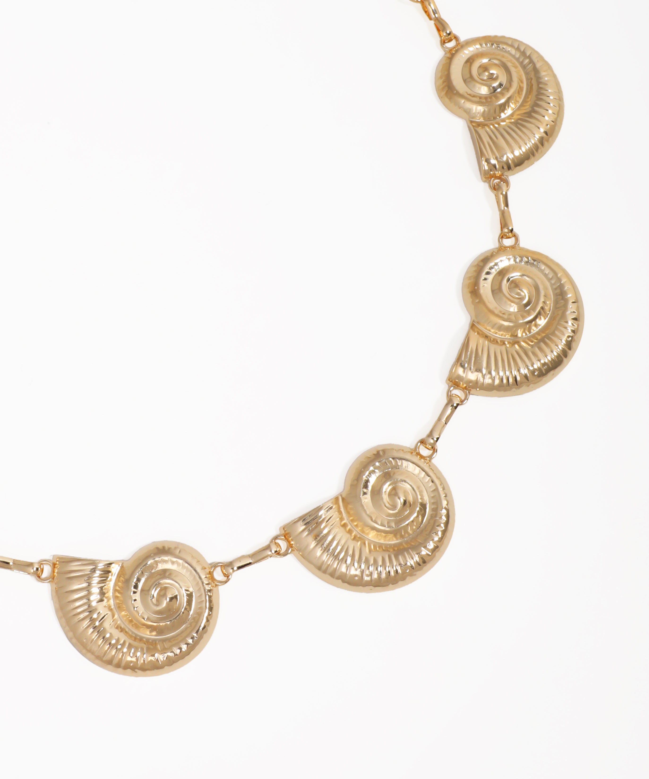 Gold necklace with circular designs on a white background