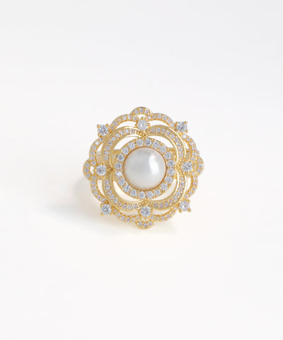 Gold brooch with a pearl and diamonds on a white background