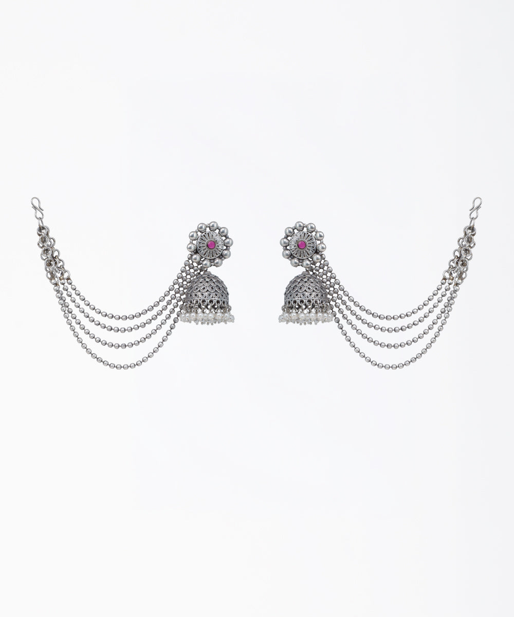 Oxidized finish jhumka earrings with red glass crystal, faux pearls, and attached beaded chains.