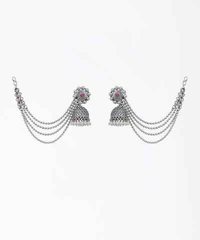 Oxidized finish jhumka earrings with red glass crystal, faux pearls, and attached beaded chains.