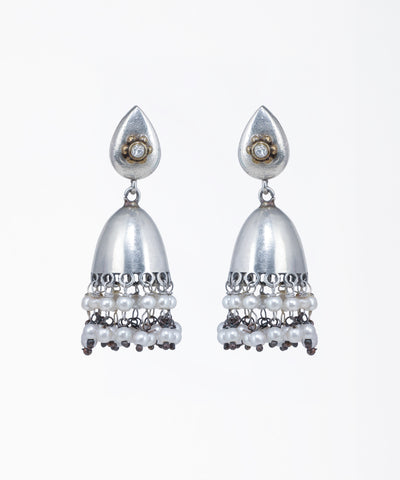 Oxidized silver-tone jhumka earrings with a teardrop stud, gold-tone floral accent, clear stone, and tiered faux pearls.