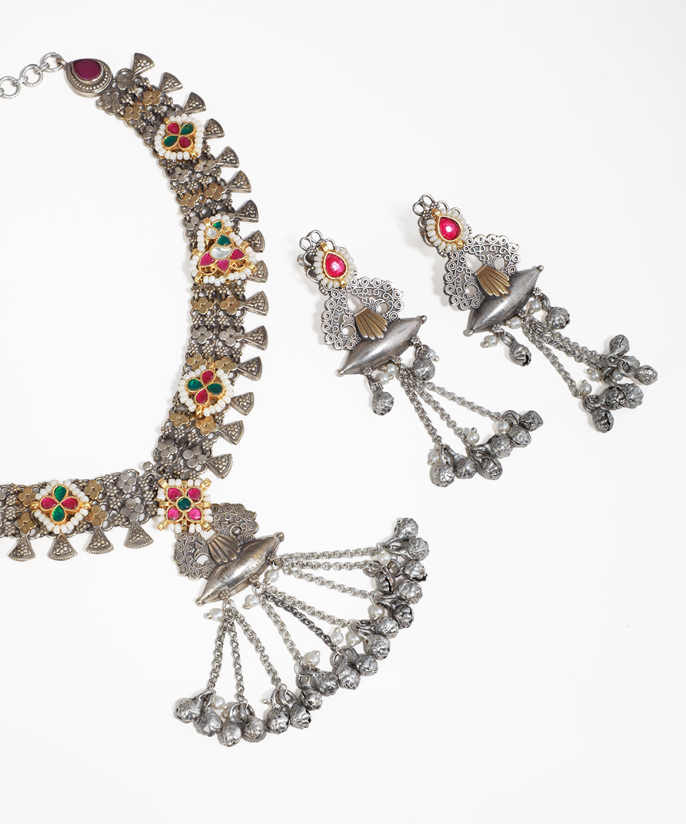 Ornate necklace and earrings set on a white background