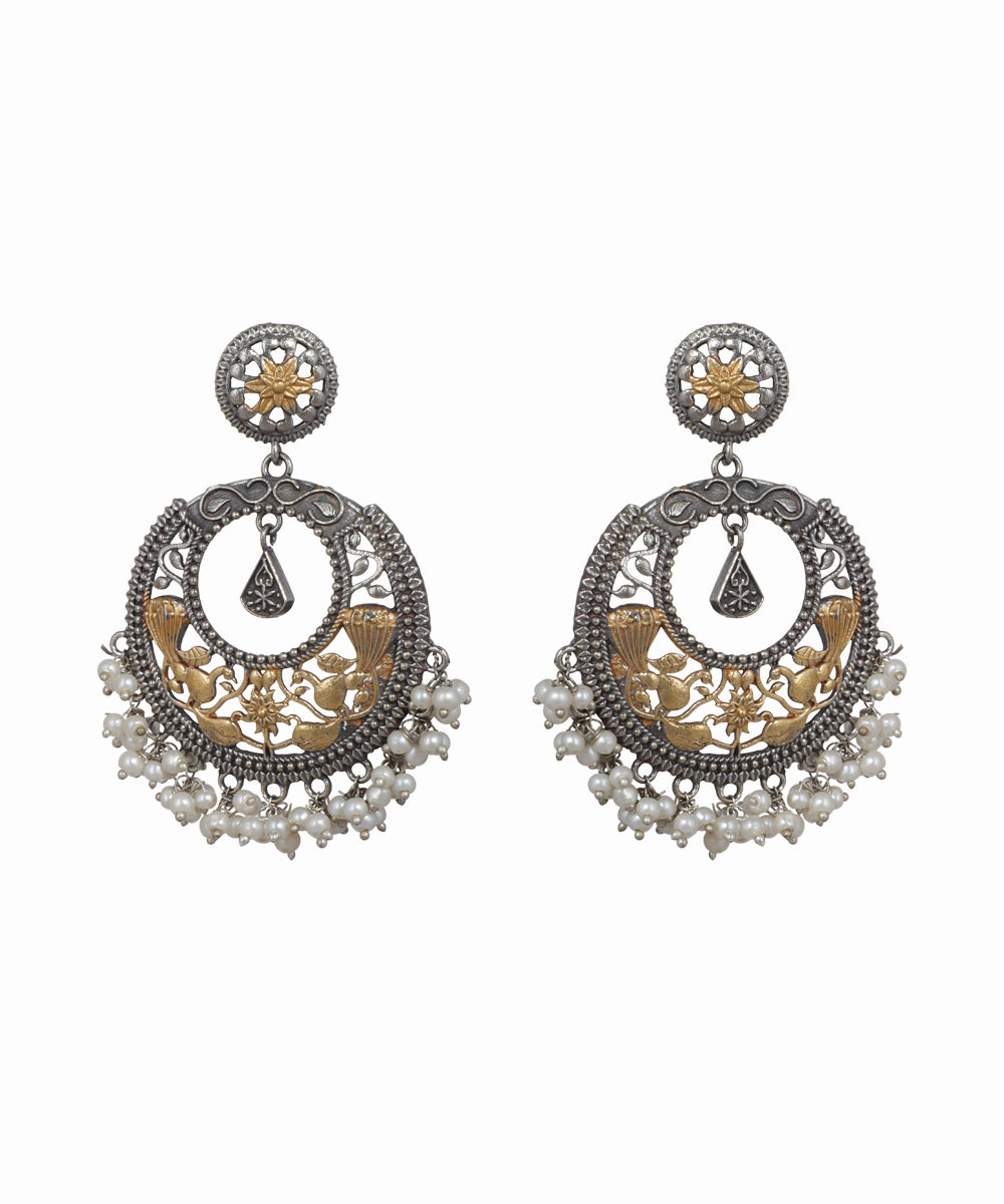 Pair of ornate earrings with intricate designs on a white background