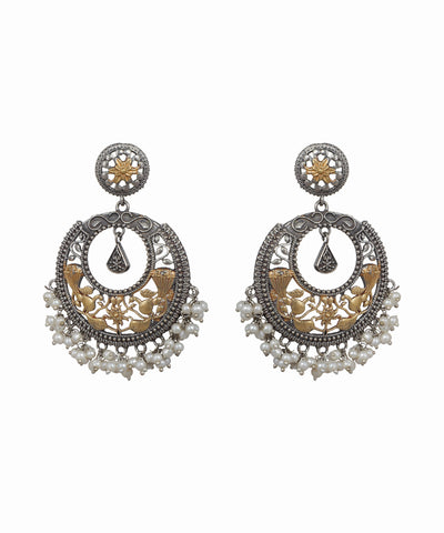 Pair of ornate earrings with intricate designs on a white background