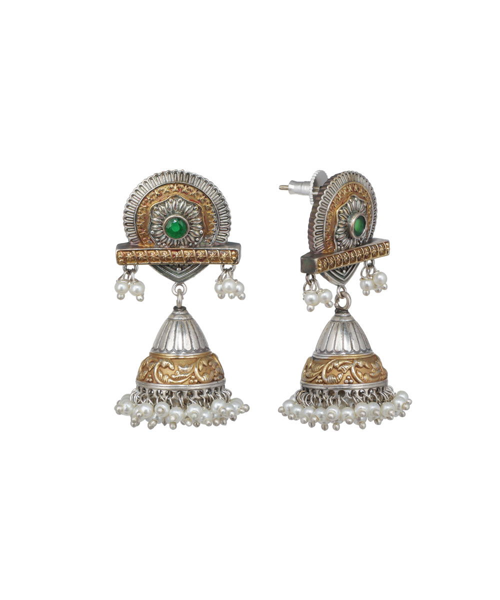 Pair of ornate earrings with green gemstones and pearl-like elements on a white background