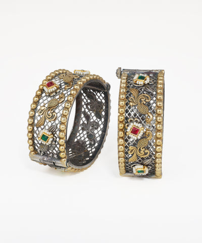 Pair of ornate hoop earrings with intricate designs on a white background